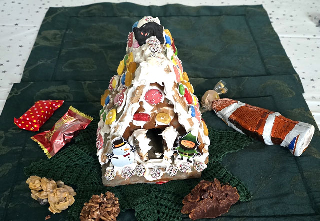 Lebkuchenhaus mit Kater und liegendem Weihnachtsmann